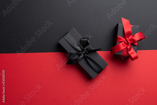 Composition of presents with pink and black ribbons on gray and pink background