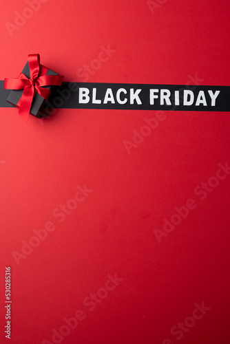 Composition of present with pink ribbon and black friday text on gray and pink background