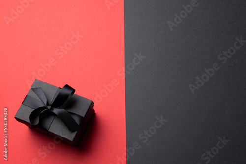 Composition of present with black ribbon on gray and pink background