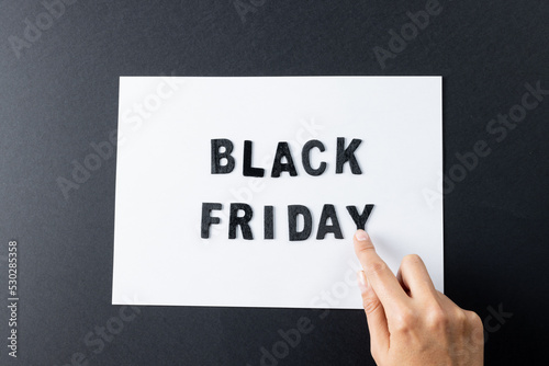 Composition of hand with black friday text on gray background