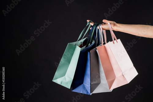 Composition of hand holding shopping bags on gray background
