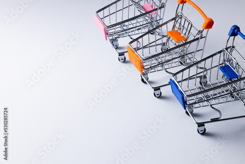 Composition of shopping carts and copy space on white background