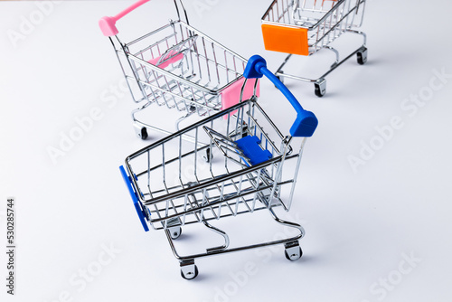 Composition of shopping carts and copy space on white background