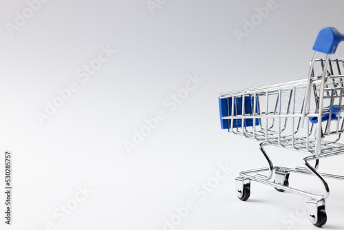Composition of shopping cart and copy space on white background