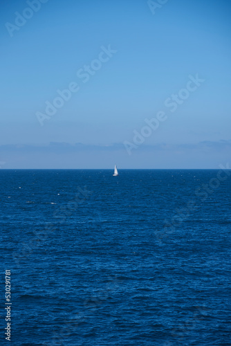 Luarca, Asturias, Spain; June 16, 2022; A beautiful sea view on the coast of Luarca. Lone boat sailing in the sea.