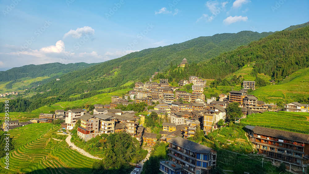 Top view of the village in the mountains. Terraced fields. Winding road. China. Picturesque landscape. Panorama.