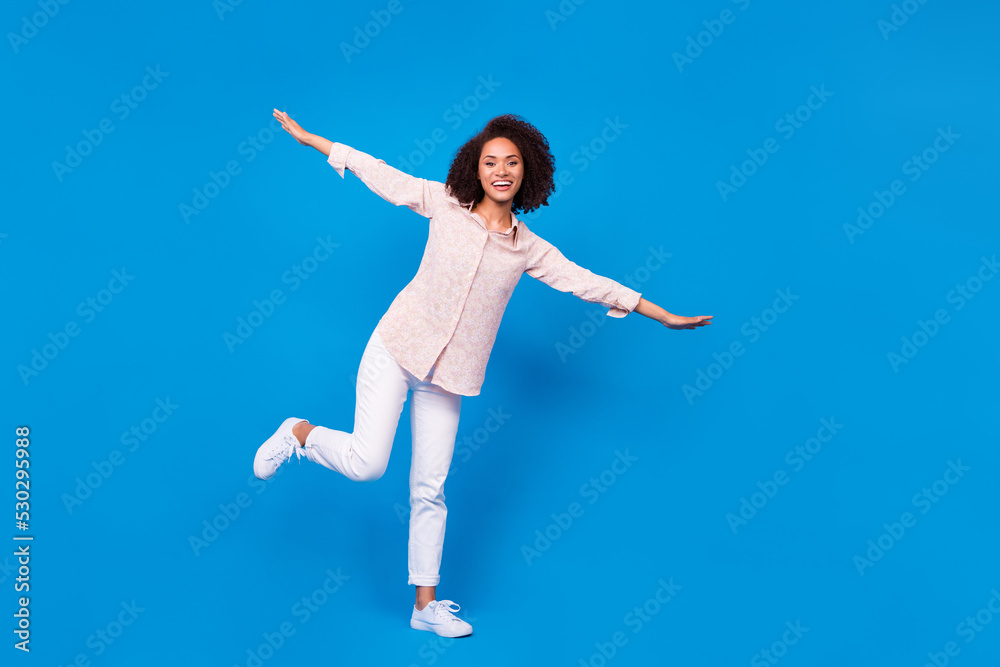 Full size photo of carefree excited lady arms wings have good mood isolated on blue color background Full size photo of carefree excited lady arms wings have good mood isolated on blue color background