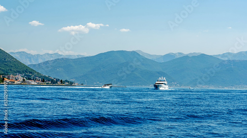Boat in Adriatic sea in Montenegro in sunny day. Touristic sailing excursions with beautiful mountains nature view