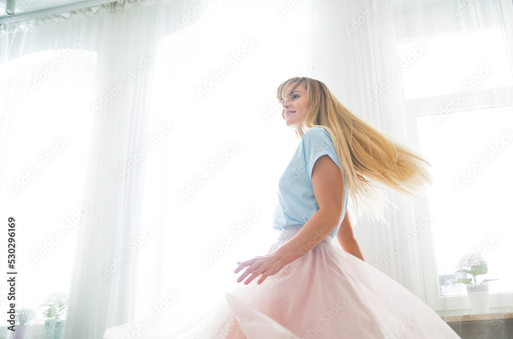 Beautiful happy woman dancing in pink skirt at home Beautiful happy woman dancing in pink skirt at home