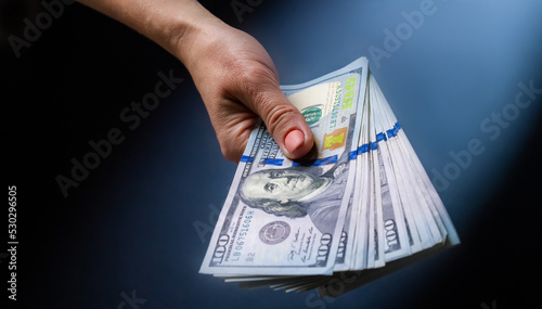 Hand holding one hundred dollar USA banknotes. American currency in cash and person with money