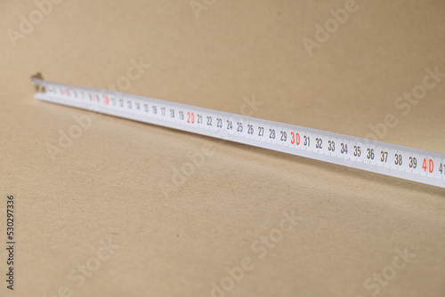 Cartridge meter. Yellow measuring tape isolated on craft paper background. With space for text