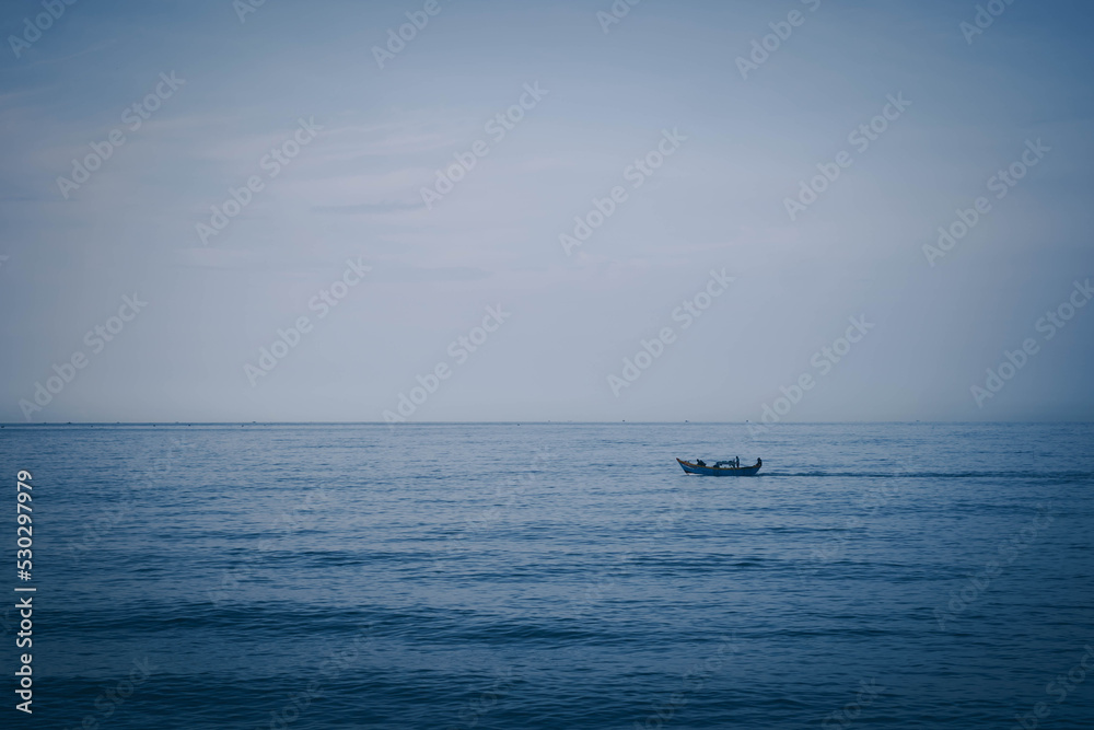 Simple background Calm dark blue sea fishing boat alone white pale Spindrift clouds Open way no limitations