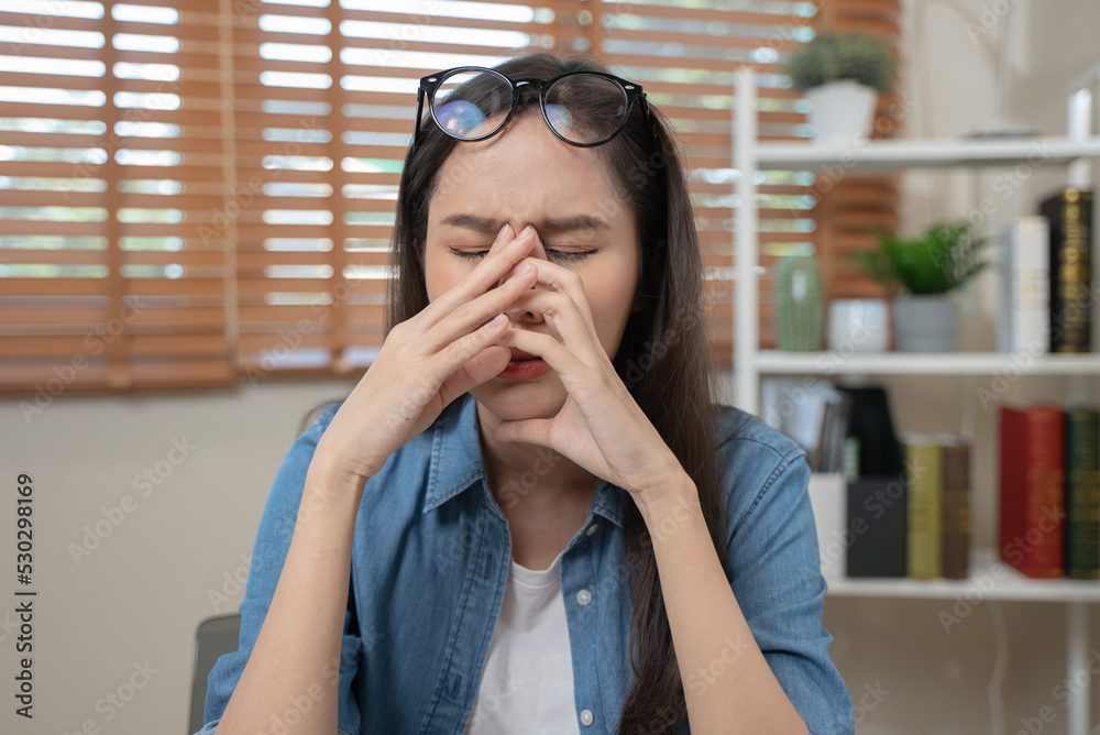 Young adult asian woman have a eyes tired after overworked looking at screen too much. Young adult asian woman have a eyes tired after overworked looking at screen too much.