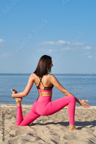 Athletic girl exercising outdoors, ready to do yoga with sports training or stretching. Healthy active lifestyle. Wellness and sport concept