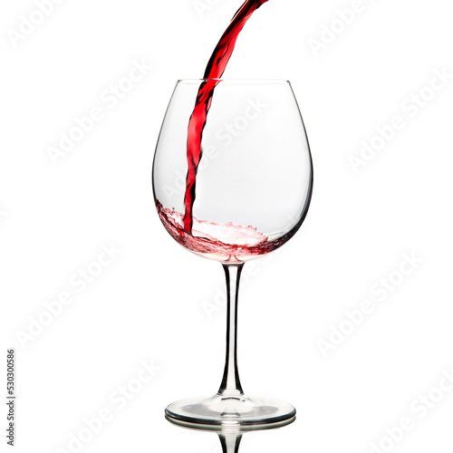 Red wine is poured into a glass goblet on a white background.