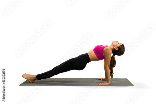 Side view of fit woman practicing reverse plank yoga pose