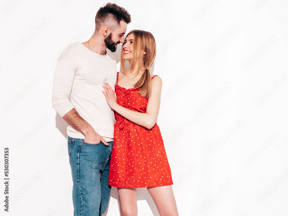 Naklejka premium Sexy smiling beautiful woman and her handsome boyfriend. Happy cheerful family having tender moments near wall in studio.Pure cheerful models hugging .Embracing each other. Cheerful and happy