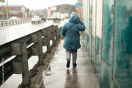 Woman walks on side of highway. Man on track. Traffic in city. © Олег Копьёв