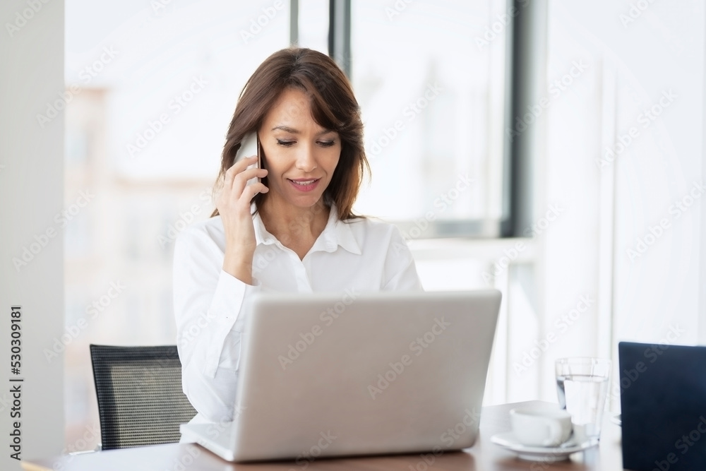 Shot of an attractive businesswoman working on a laptop in an office Shot of an attractive businesswoman working on a laptop in an office