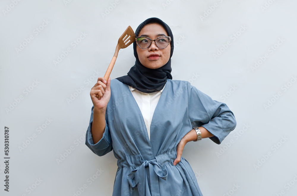 a young woman is thinking of cooking on a solid background a young woman is thinking of cooking on a solid background