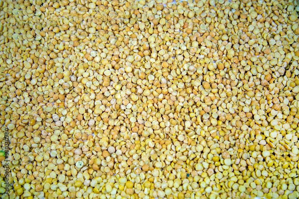 Background of crushed peas (Latin Písum) with beautiful yellow grains. Cereals legumes useful products agriculture.