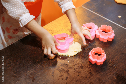 a small child is preparing cupcakes in the kitchen