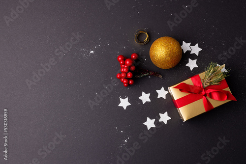 Image of christmas decoration with gift  bauble and copy space on black background