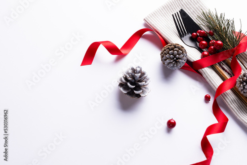 Image of christmas place setting with cutlery and copy space on white background