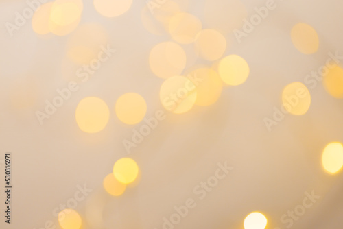 Image of out of focus christmas fairy lights and copy space on cream background