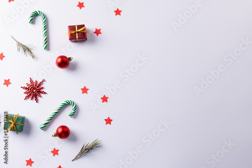 Christmas canes, gifts, christmas tree twigs and decorations over white background