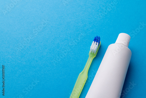 Image of toothbrush and toothpaste on blue surface