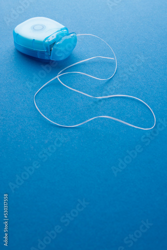 Vertical image of dental string on blue surface