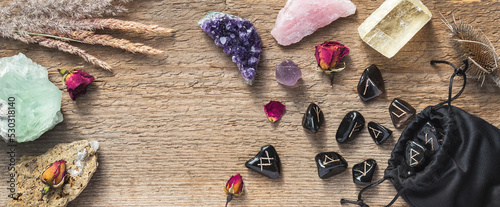 Tablou pe pânză Set of different crystals and rune stones on wood