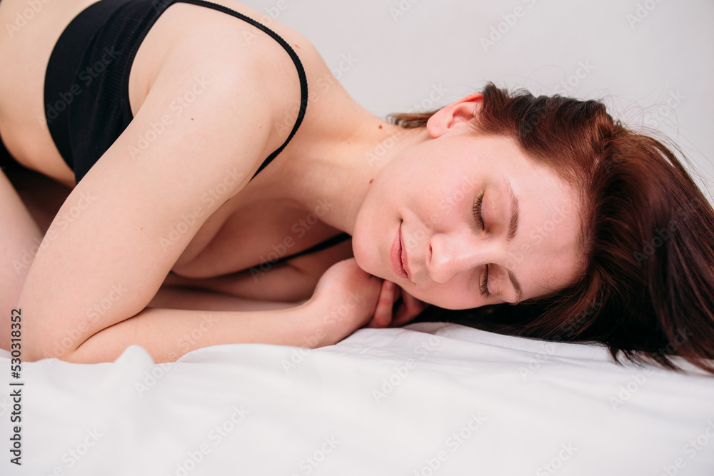 Portrait of a young beautiful brunette lying in bed wearing underwear Portrait of a young beautiful brunette lying in bed wearing underwear