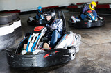Young sportive people driving sport cars for karting in a circuit lap in sport club