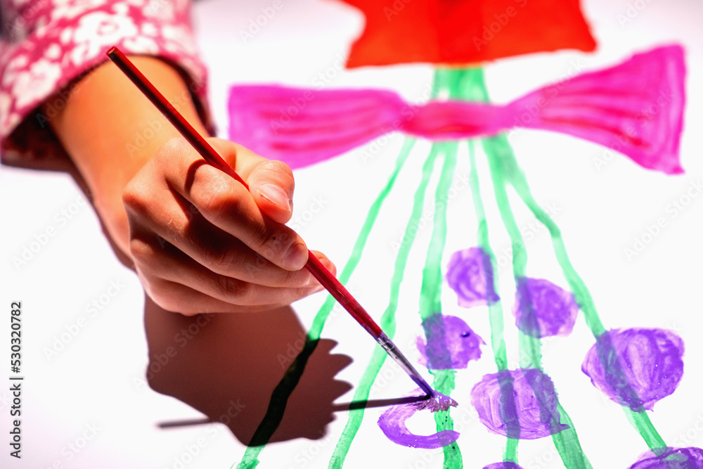 Child's hand painting picture in art studio. Selective focus on hand. Child's hand painting picture in art studio. Selective focus on hand.