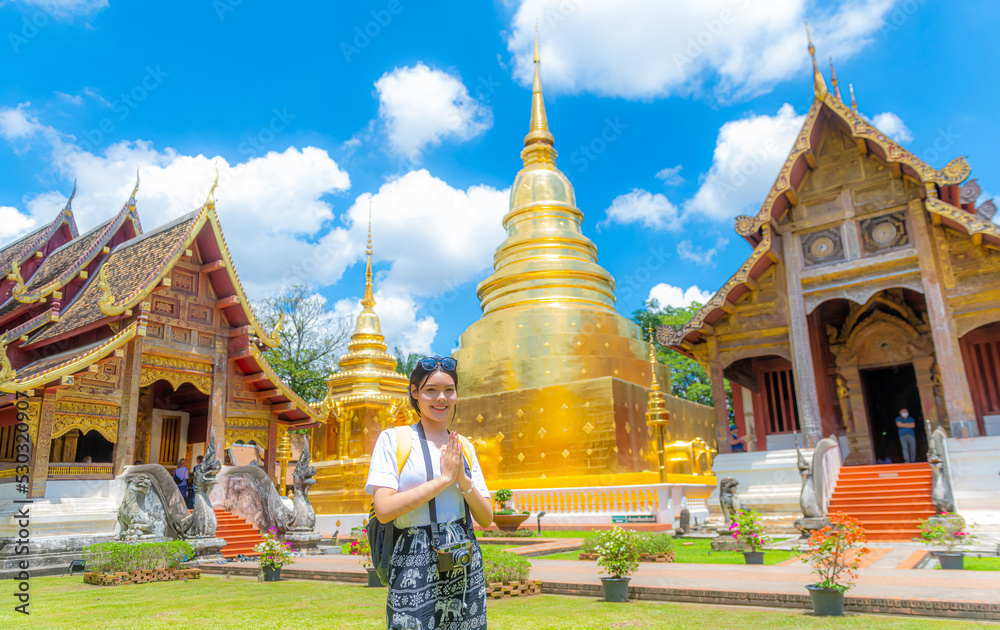 Fototapeta premium A young woman praying at Wat Phra Singh, a famous tourist attraction and attraction in Chiang Mai, Thailand.