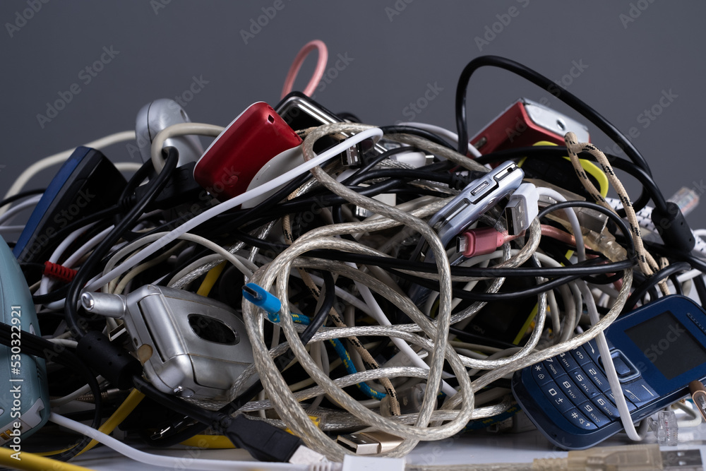 Pile of tangled old smart technology wires, charging cables and used