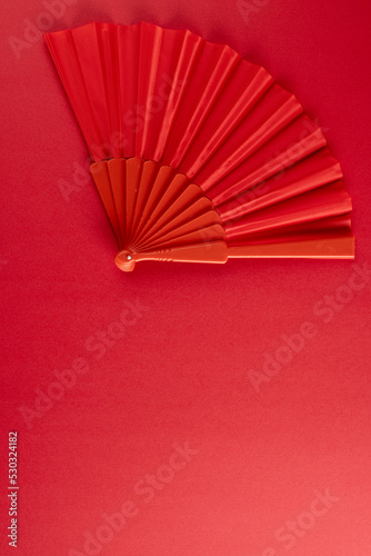 Composition of traditional chinese fan on red background
