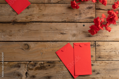 Composition of red flowers and envelopes on wooden background