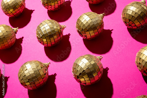 Composition of close up of new years baubles on pink background