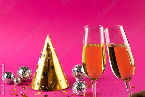 Composition of close up of new years champagne and decorations on pink background