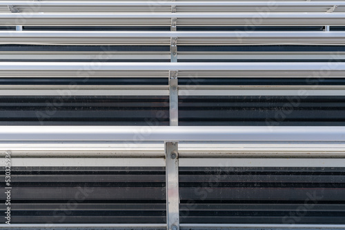 Close-Up of empty metal stadium bleacher bench seats.  Nondescript location with no people in image.  Not a ticketed event.  