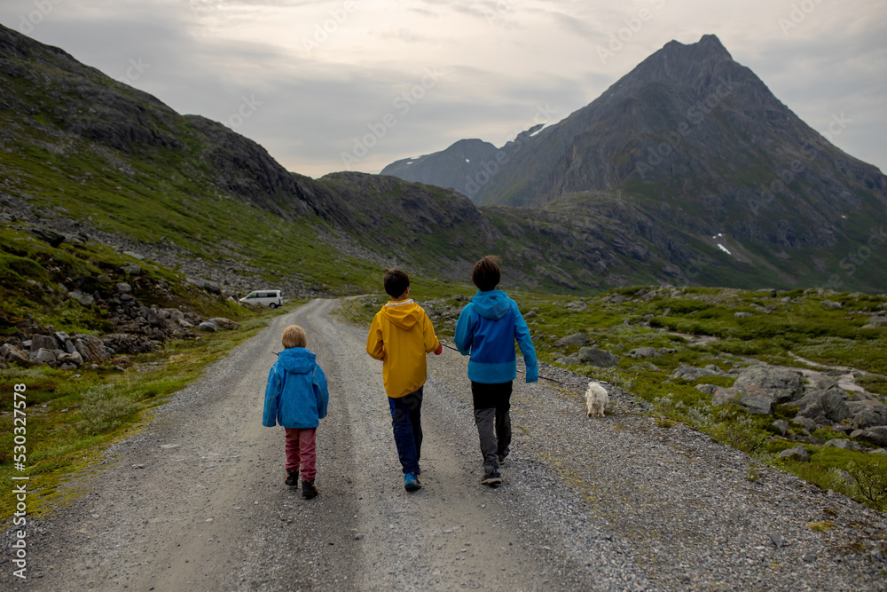 Family with children and dog, hiking in Litlefjellet on sunset, enjoying amazing view from the top of hiking trail