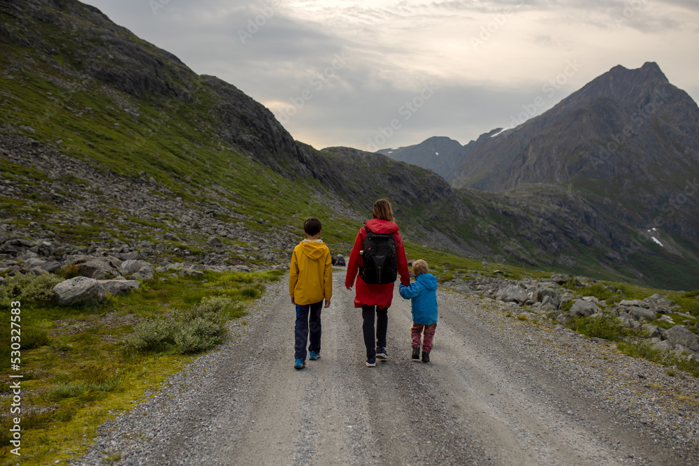 Family with children and dog, hiking in Litlefjellet on sunset, enjoying amazing view from the top of hiking trail