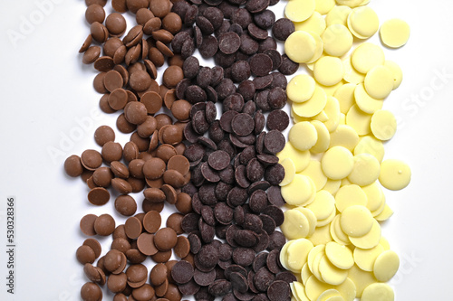 Close up of three types of couverture chocolate. Chocolate callets isolated on white. photo