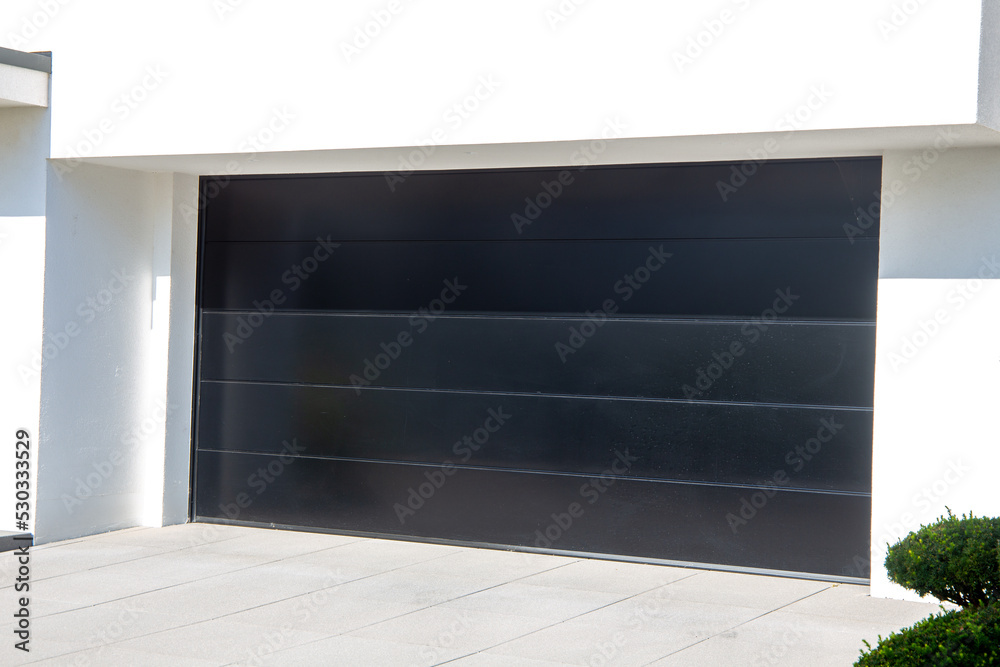Neues schwarzes Garagentor (Sektionaltor) an einem Wohnhaus