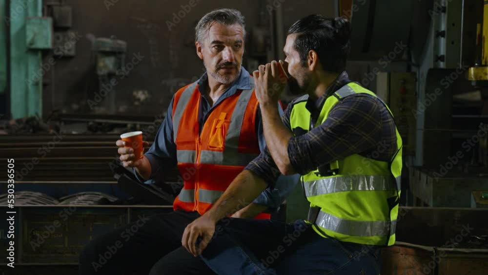 the worker is resting and conversing with his colleague in the factory the worker is resting and conversing with his colleague in the factory