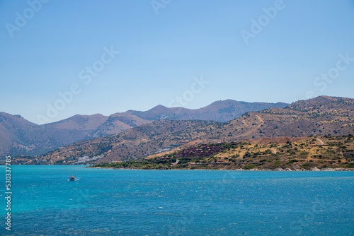 Turquoise blue sea panoramic view with a mountain in the background