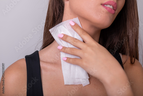 Young woman in black tank top clean neck with wet wipes